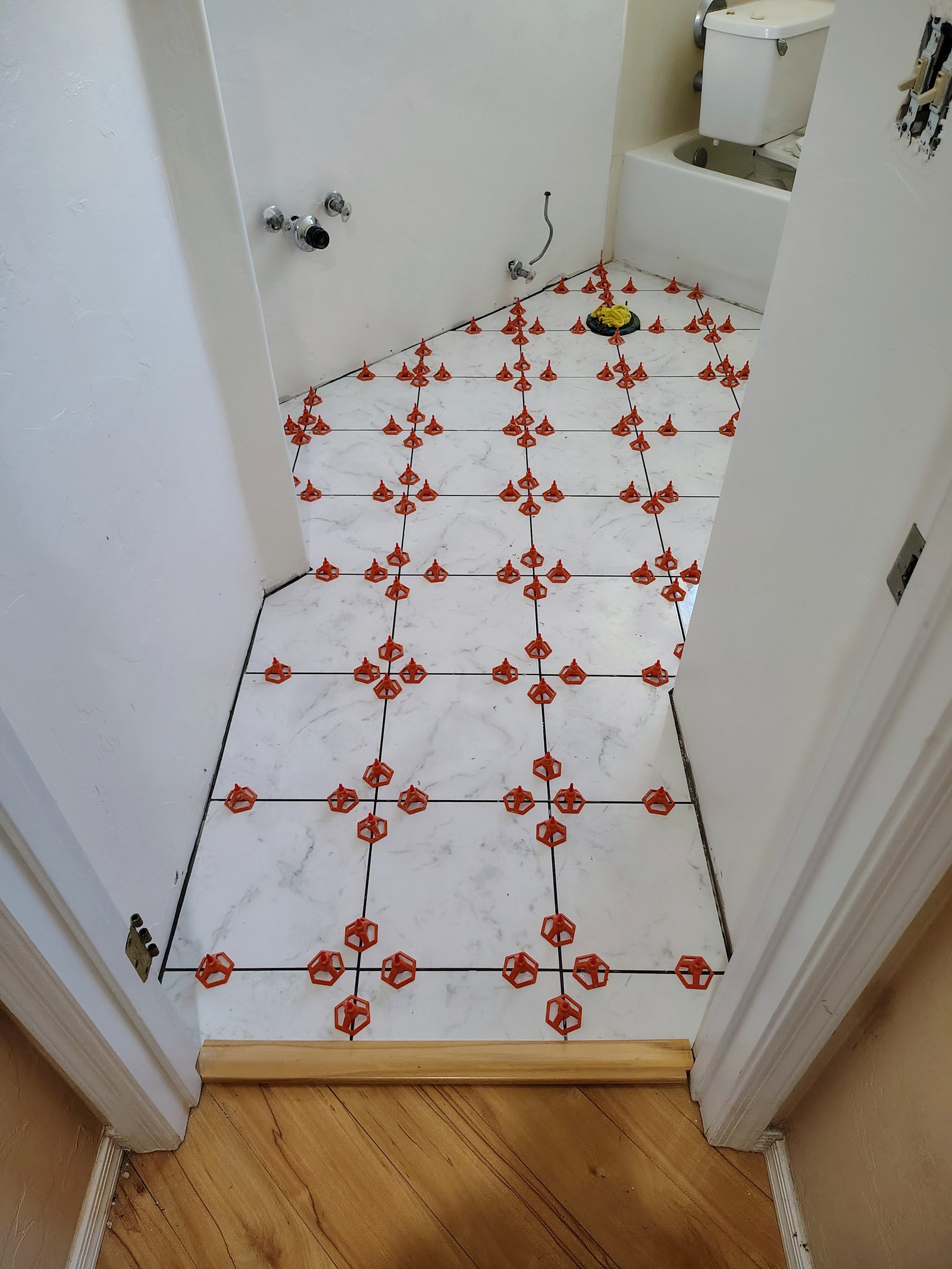 Bathroom marble tile floor installation with spacers Tucson AZ